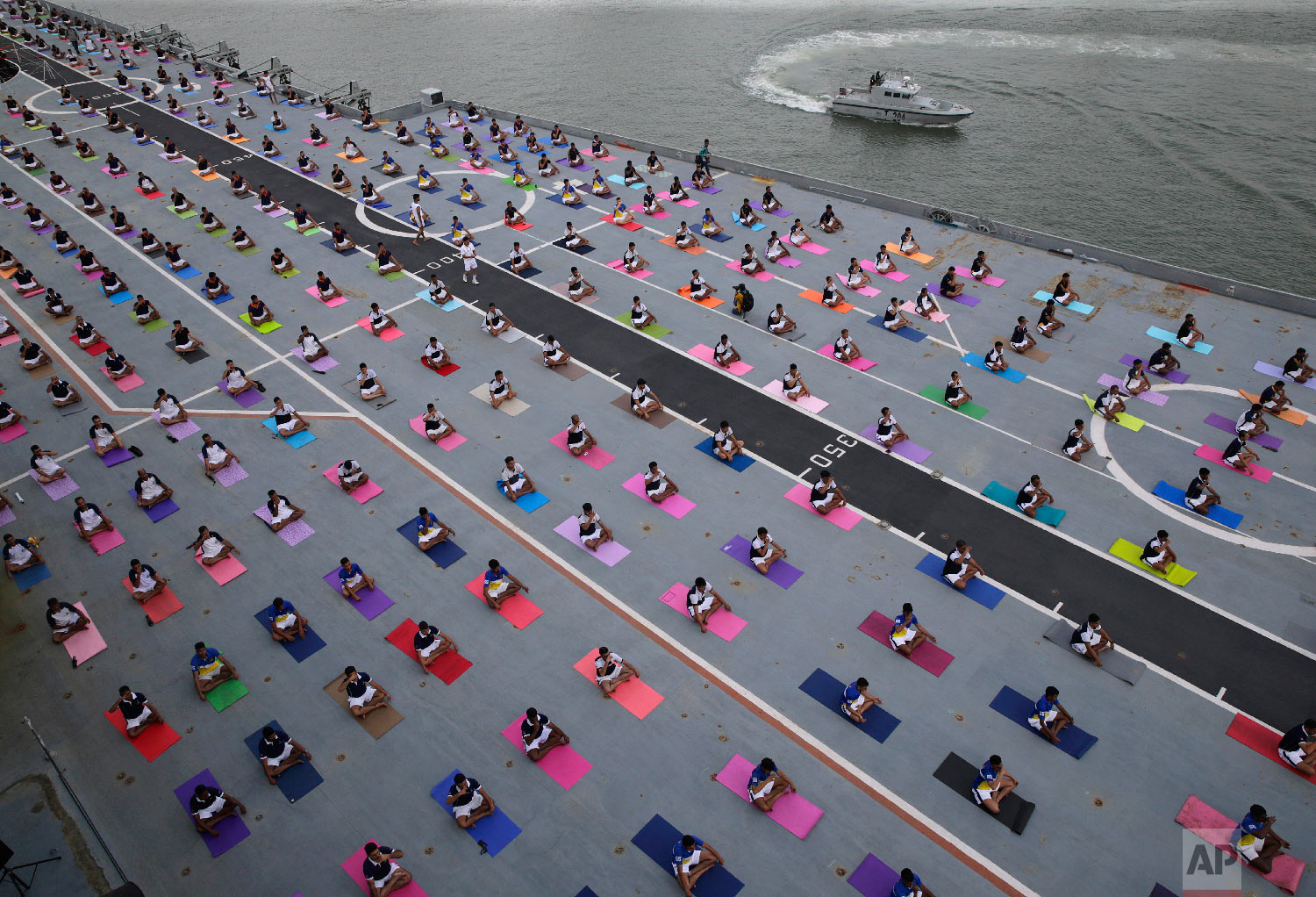  Indian defense personnel perform yoga on the deck of Indian naval aircraft carrier Viraat as they mark International Yoga Day in Mumbai, India Thursday, June 21, 2018. Millions of yoga enthusiasts across the world Thursday took part in mass yoga eve