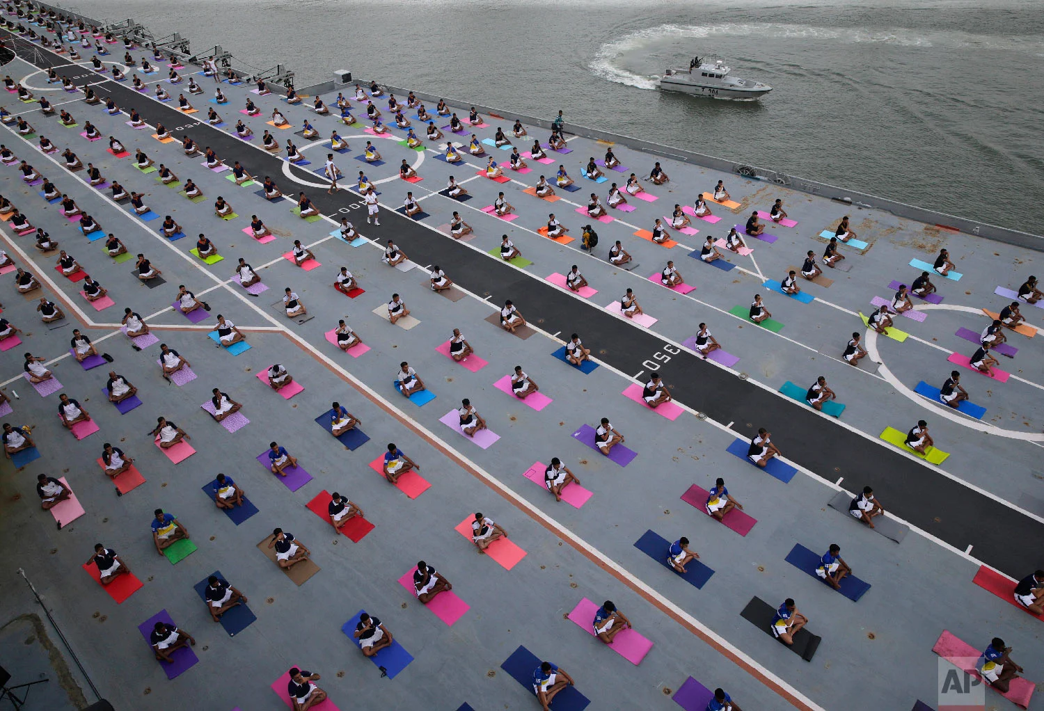 Indian defense personnel perform yoga on the deck of Indian naval aircraft carrier Viraat as they mark International Yoga Day in Mumbai, India Thursday, June 21, 2018. Millions of yoga enthusiasts across the world Thursday took part in mass yoga events to mark International Yoga Day. (AP Photo/Rafiq Maqbool)
