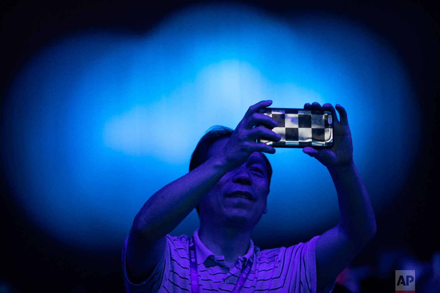  A spectator takes a cellphone photo of the CHAIN Cup at the China National Convention Center in Beijing, Saturday, June 30, 2018. A computer running artificial intelligence software defeated two teams of human doctors in accurately recognizing malad