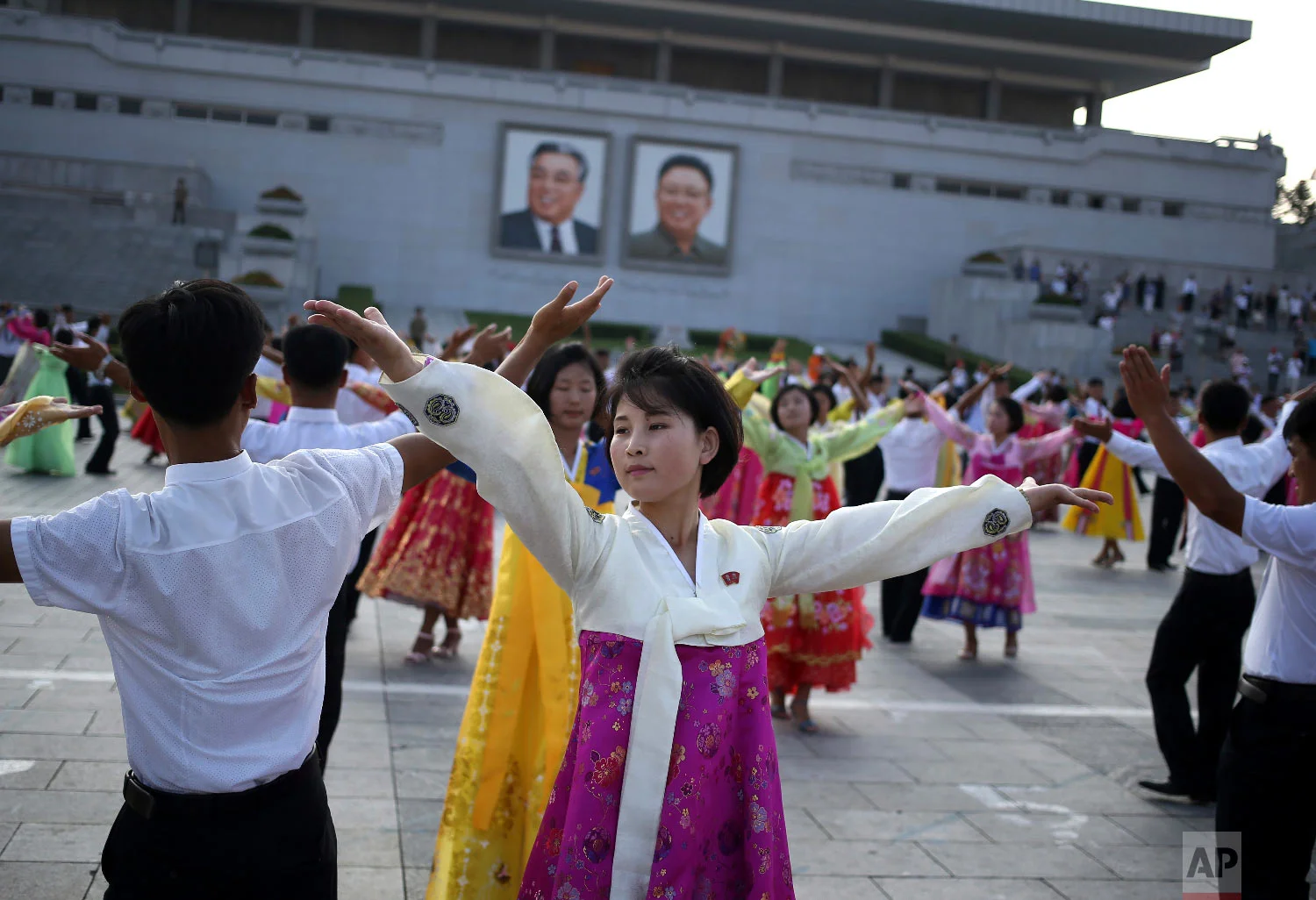 North Koreans take part in a mass dance during the commemoration of the 65th anniversary of the end of the Korean War, which the country celebrates as the day of "victory in the fatherland liberation war", at Kim Il Sung Square in Pyongyang, North Korea, Friday, July 27, 2018. (AP Photo/Dita Alangkara)