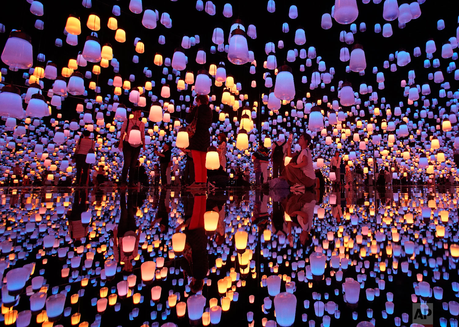  Visitors walk through the installation of "Forest of Resonating Lamps" at the Mori Building Digital Art Museum in Tokyo, Thursday, June 21, 2018. Mori Building, a Japanese real estate company and teamLab, digital art collective company, have joined 