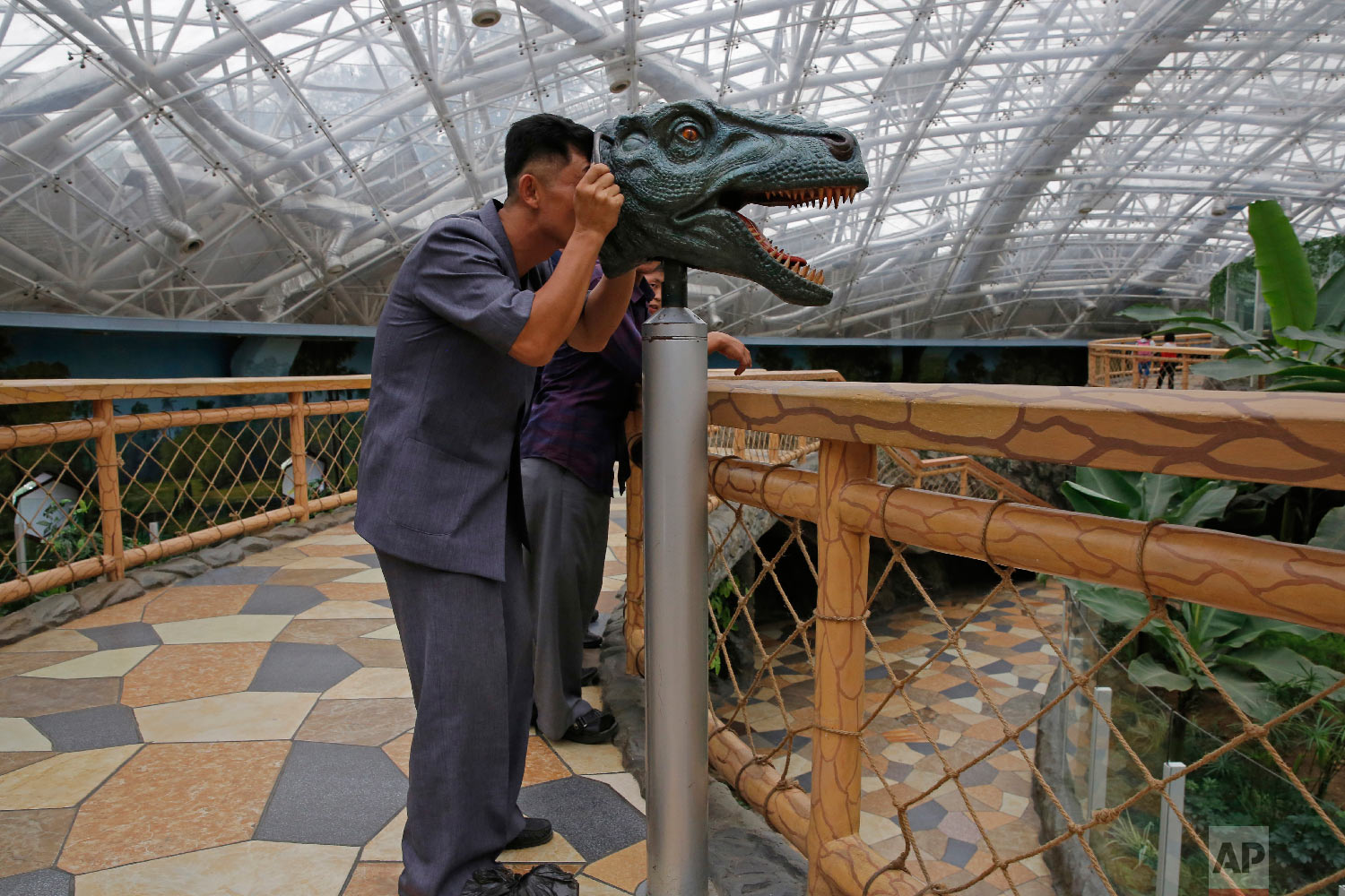  A North Korean man looks through a device to study the vision of a dinosaur, at the Central Zoo in Pyongyang, North Korea Saturday, Sept. 15, 2018. (AP Photo/Kin Cheung) 