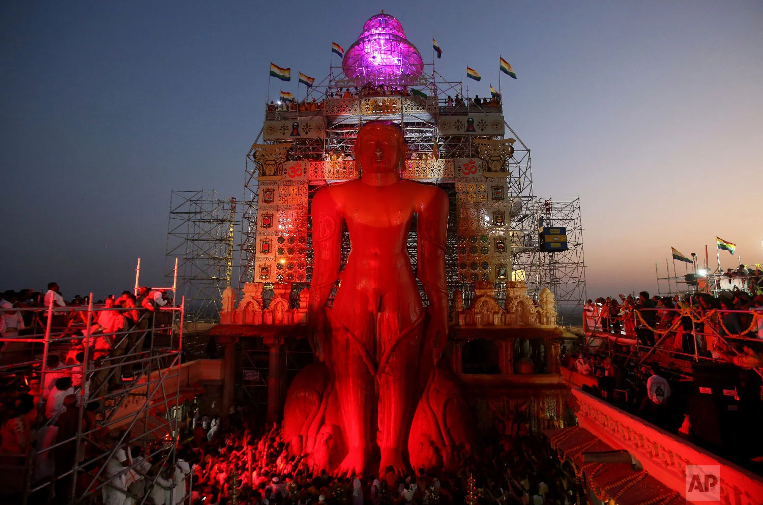 Vermilion runs down the 58.8-foot monolithic statue of Jain god Gomateshwara at Shravanabelagola 145 kilometers (91 miles) west of Bangalore, India, Saturday, Feb. 17, 2018. Hundreds of thousands of Jain devotees will attend the Mahamastabhisheka or head anointing ceremony of the 1,037-year-old statue Gomateswara (Lord Bahubali), a tradition held every 12 years since AD 981. The 1,037-year-old statue is bathed with milk, turmeric, vermilion, saffron, sandalwood paste, powder of medicinal herbs and gold coins. (AP Photo/Aijaz Rahi)