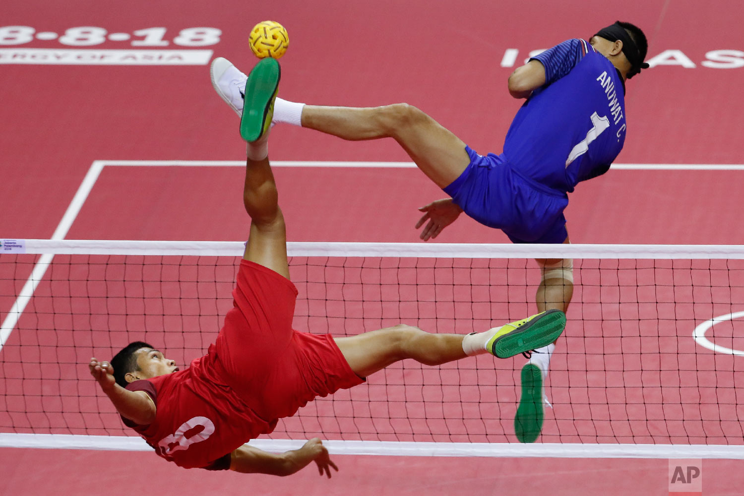  Lao's Kantana Nanthisen, left, kicks a ball against Thailand's Anuwat Chaichana during men's sepak takraw team doubles final match at the 18th Asian Games in Palembang, Indonesia, Saturday, Aug. 25, 2018. (AP Photo/Vincent Thian) 