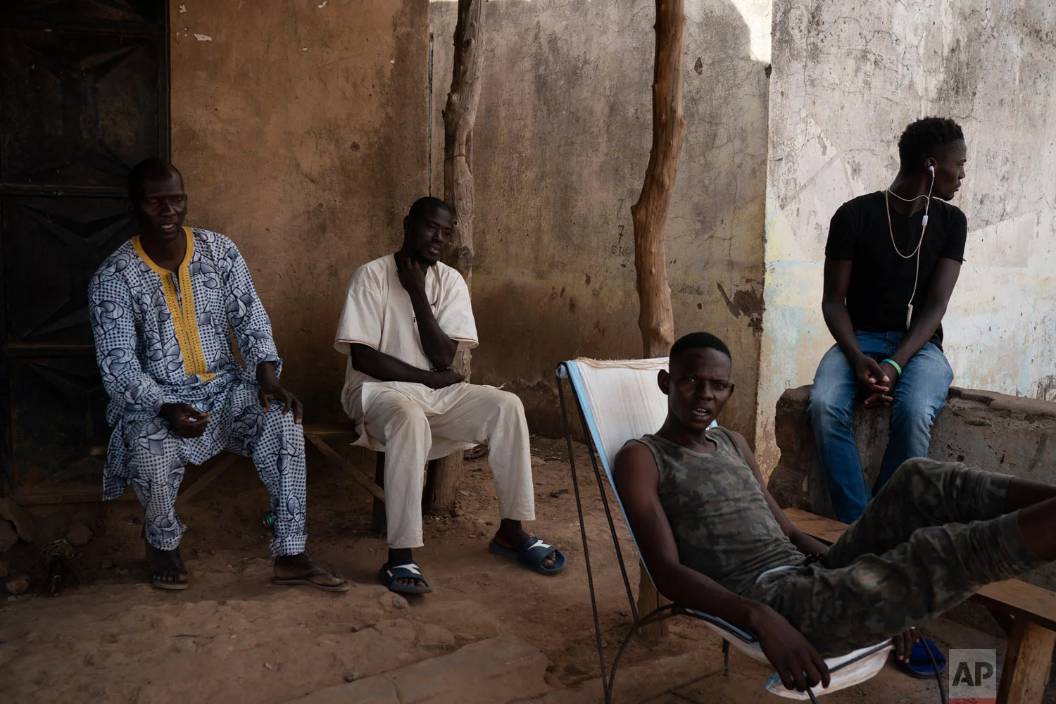 People sit outside in the shade in a village on Nov. 24, 2018, near Goudiry, Senegal. (AP Photo/Felipe Dana)