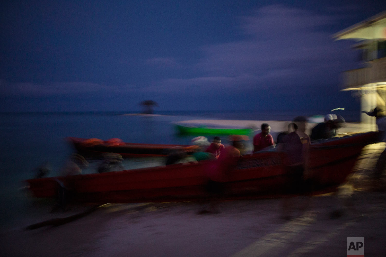  In this Sept. 10, 2018 photo, Miskito fishermen push a boat onto the shore on Cay Savannah, Honduras, at the end of a fishing sea cucumber trip. (AP Photo/Rodrigo Abd) 