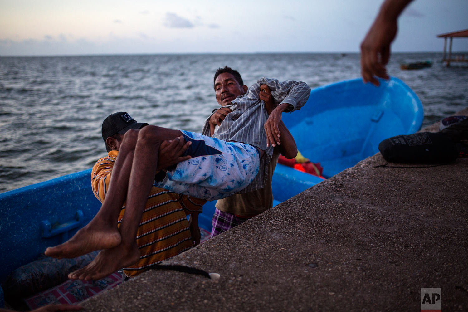  In this Sept. 4, 2018 photo, diver Saul Ronaldo Atiliano, 45, is lifted onto the dock after traveling via boat to Puerto Lempira, Honduras, to receive decompression sickness therapy in a hyperbaric chamber. (AP Photo/Rodrigo Abd) 