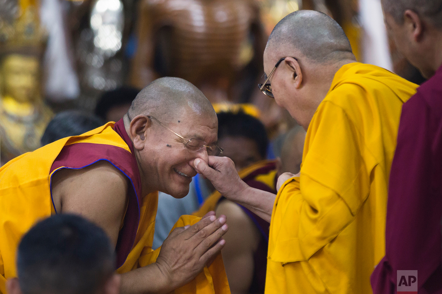 Tibetan spiritual leader the Dalai Lama playfully pinches the nose of a senior monk as he arrives to give a talk to Tibetan youth in Dharmsala, India, Thursday, June 7, 2018. (AP Photo/Ashwini Bhatia)