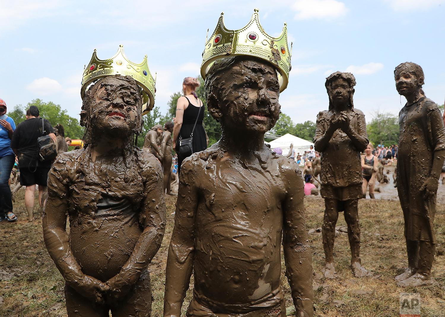 Molly Kofahl, 4, left, and Charles Daviskiba, 3, pose after being crowned Mud Day Queen and King during Mud Day at the Nankin Mills Park, Tuesday, July 10, 2018, in Westland, Mich. (AP Photo/Carlos Osorio)