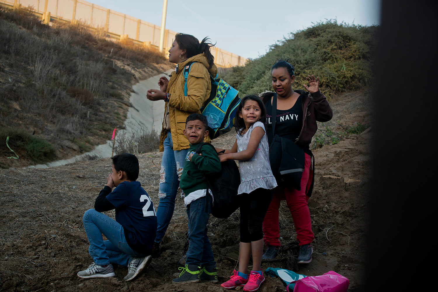  In a photo taken from the Tijuana, Mexico, side of the border, Honduran migrants react as they surrender to the U.S. Border Patrol after crossing the border wall in to the United States, Sunday, Dec. 2, 2018. (AP Photo/Ramon Espinosa) 