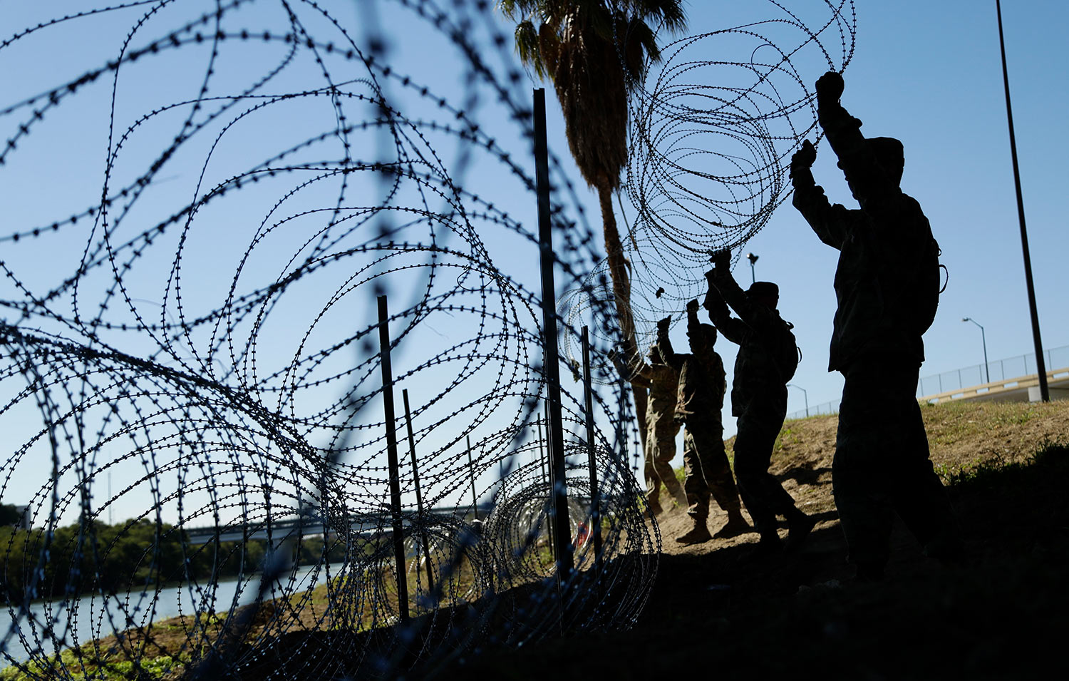  Members of the U.S. military install multiple tiers of concertina wire along the banks of the Rio Grande near the Juarez-Lincoln Bridge at the U.S.-Mexico border, Friday, Nov. 16, 2018, in Laredo, Texas. (AP Photo/Eric Gay) 