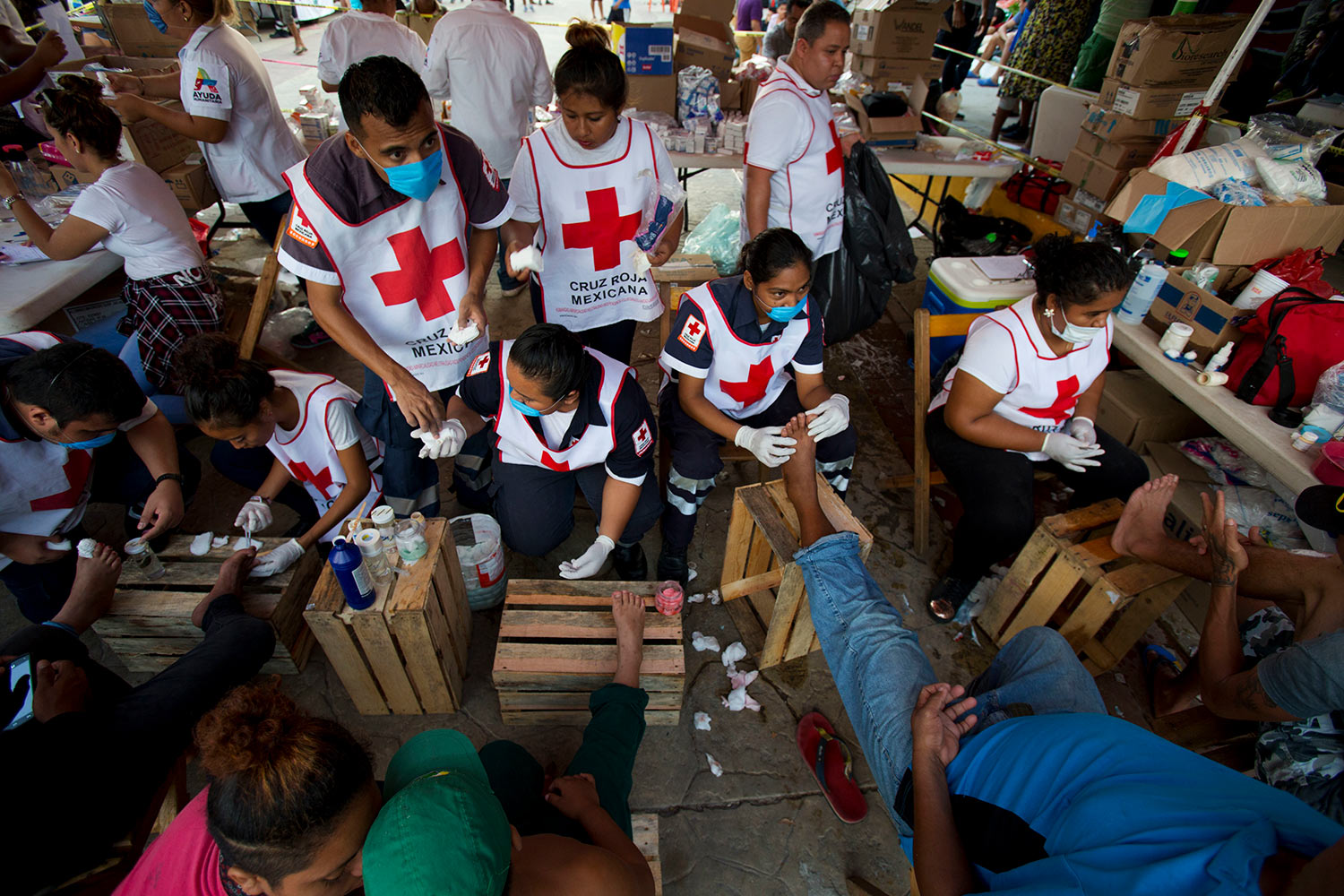  Volunteers from the Mexican Red Cross treat the blistered and cut feet of Central American migrants as a caravan of thousands stops for the night in Arriaga, Mexico, Friday, Oct. 26, 2018. (AP Photo/Rebecca Blackwell) 