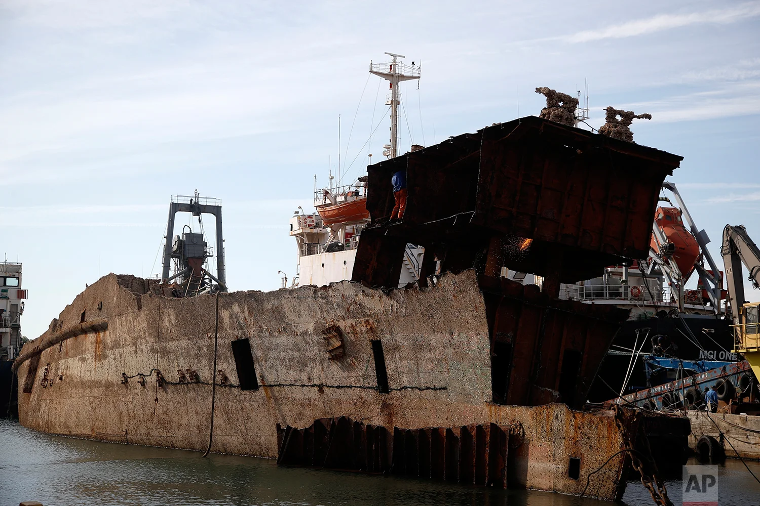 In this Monday, Nov. 5, 2018 photo, in a shipyard of Perama, west of Athens, workers cut up the rusted remains of a ferry that was recovered after spending years as a shipwreck. (AP Photo/Thanassis Stavrakis)