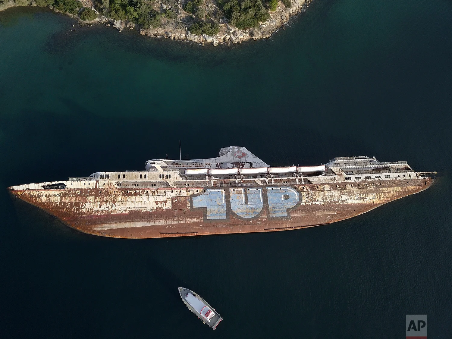 In this Friday, Dec. 4, 2018 photo, a half sunken cruise ship lays on its side, in the Gulf of Elefsina, west of Athens. (AP Photo/Thanassis Stavrakis)