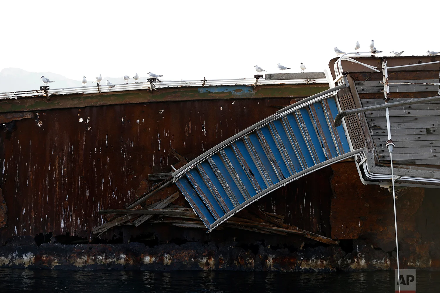 In this Friday, Dec. 4, 2018 photo, seagulls sit on a half sunken cruise ship in the Gulf of Elefsina, west of Athens. (AP Photo/Thanassis Stavrakis)