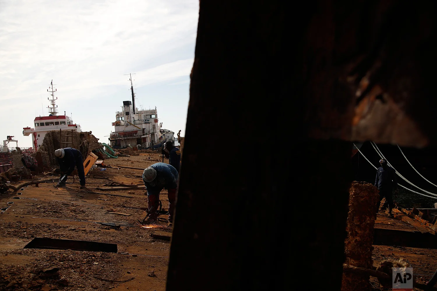 In this Monday, Nov. 5, 2018 photo, in a shipyard of Perama, west of Athens, workers cut up the rusted remains of a ferry that was recovered after spending years as a shipwreck. (AP Photo/Thanassis Stavrakis)
