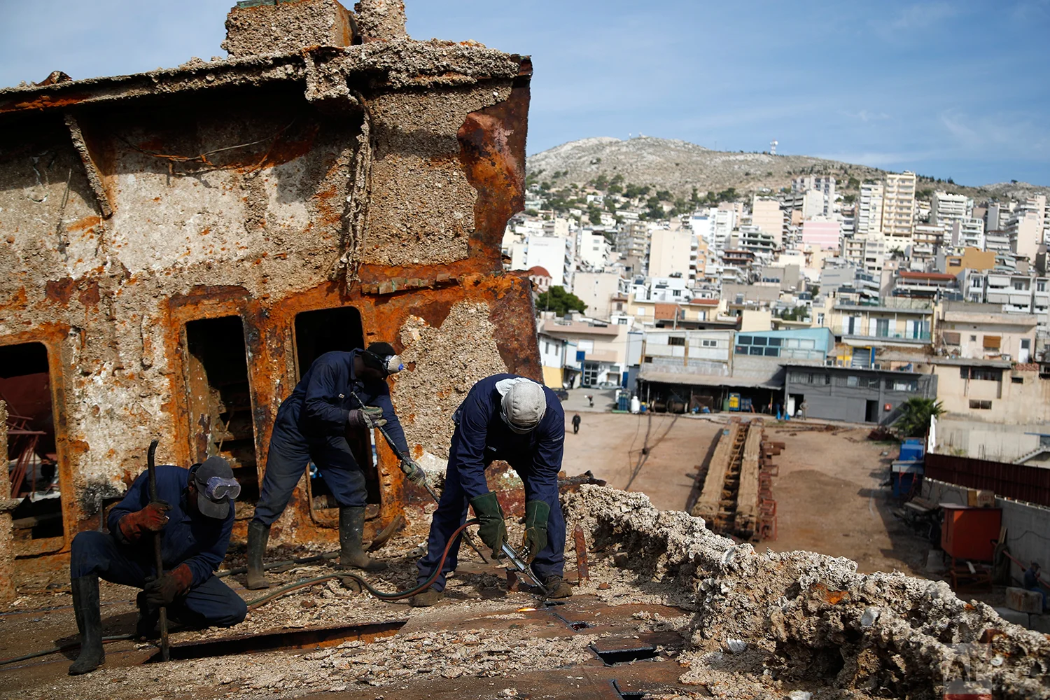 In this Monday, Nov. 5, 2018 photo, in a shipyard of Perama, west of Athens, workers cut up the rusted remains of a ferry that was recovered after spending years as a shipwreck. (AP Photo/Thanassis Stavrakis)
