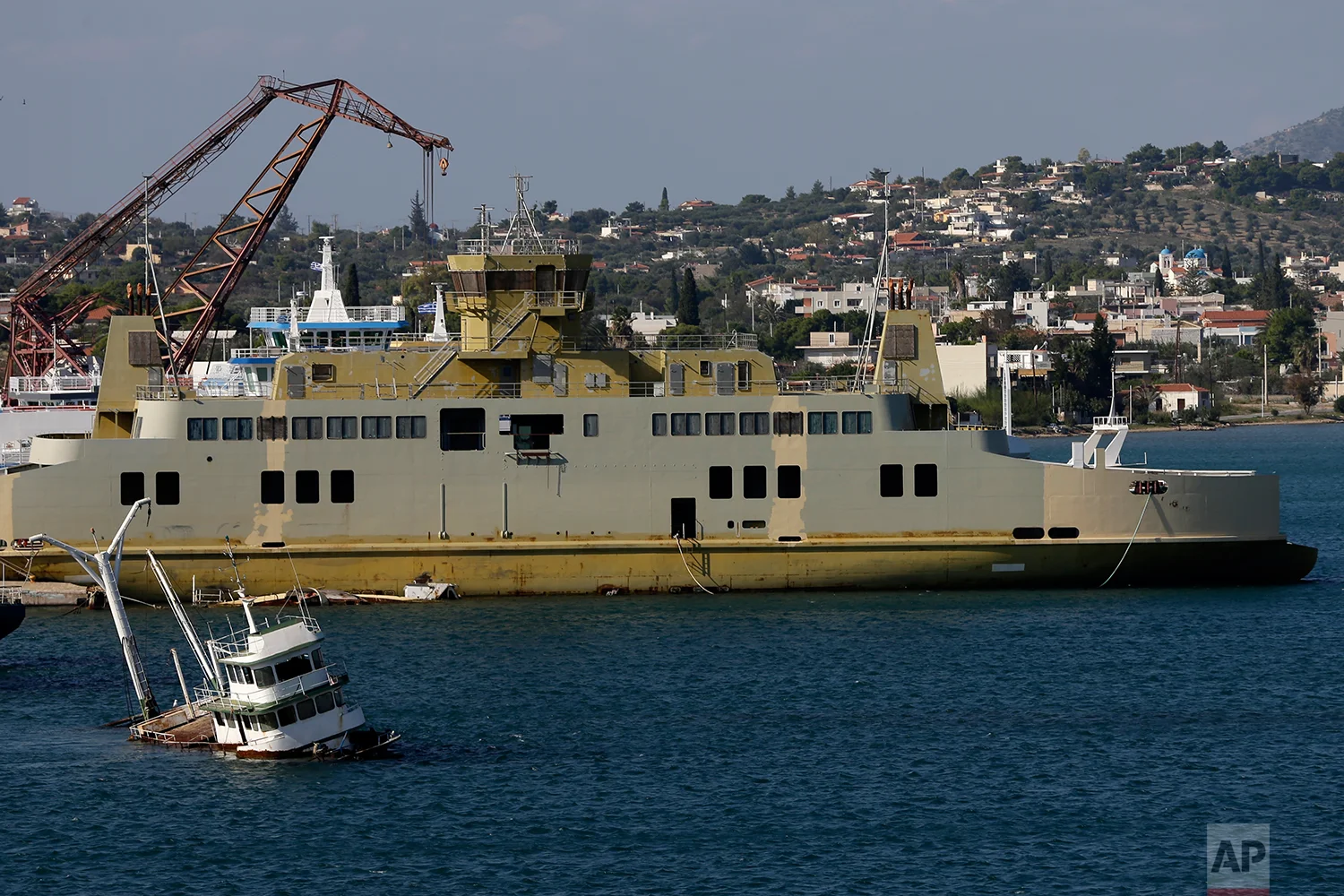 In this Tuesday, Nov. 6, 2018 photo, a half sunken small boat is visible near a shipyard in Salamina island, west of Athens. (AP Photo/Thanassis Stavrakis)