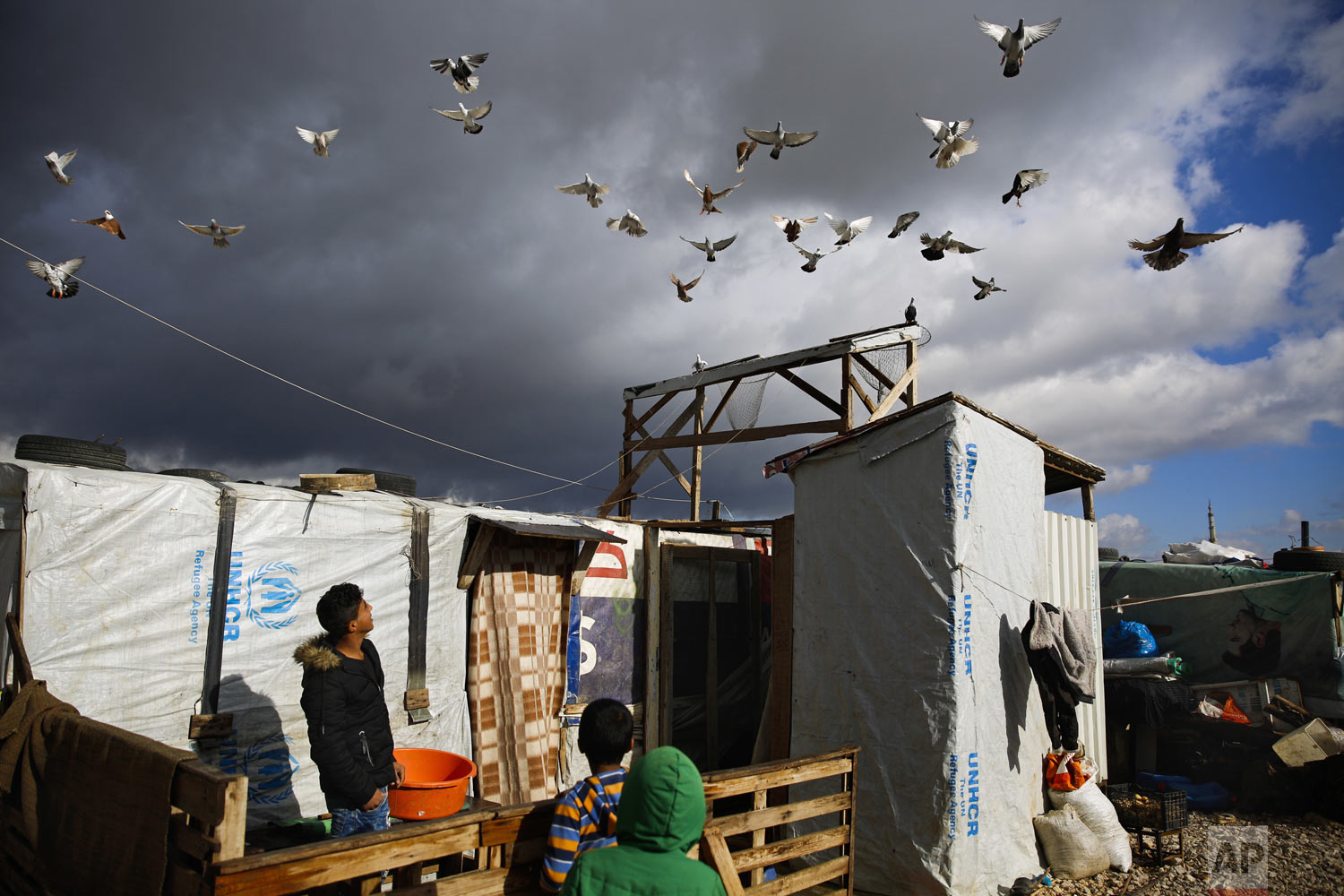  A boy watches his pigeons fly at an informal refugee camp in Zahle city in the eastern Bekaa valley, Lebanon, Monday, Dec. 31, 2018. Temperatures in Bekaa valley took a dip reaching zero degrees Celsius (32 degrees Fahrenheit) Monday early morning. 