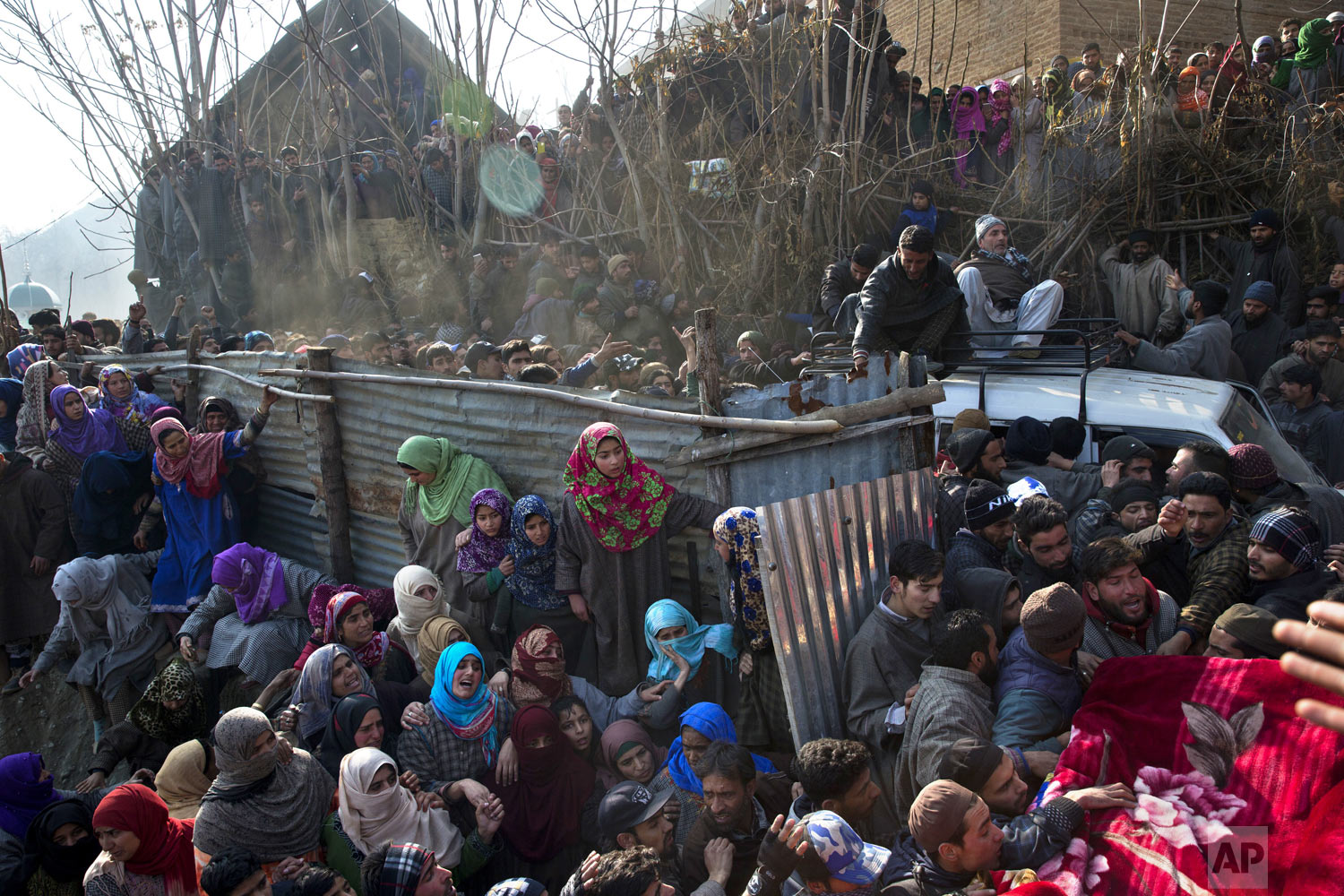  Villagers watch as a vehicle carrying the body of local rebel Muzamil Ahmed Dar arrives at his residence in Rahmoo village south of Srinagar, Indian-controlled Kashmir, Saturday, Dec. 29, 2018. Anti-India protests and clashes erupted in disputed Kas