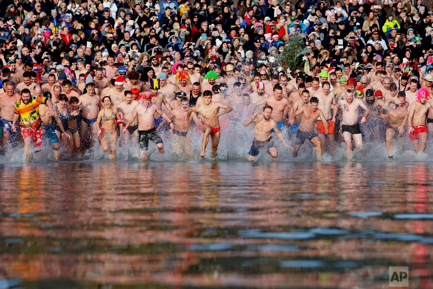  Swimmers run into the chilly waters of Lake Balaton during the eighth annual New Year's event in Szigliget, southwest of Budapest, Hungary, Tuesday, Jan. 1, 2019. (Gyorgy Varga/MTI via AP) 