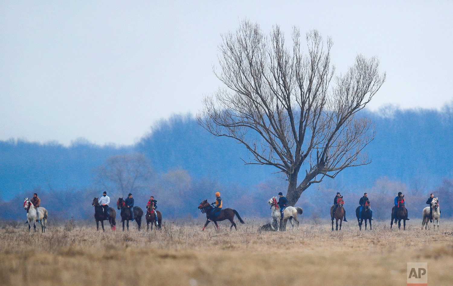 Villagers on horseback wait for the start of an Epiphany celebration horse race in Pietrosani, Romania, Sunday, Jan. 6, 2019. (AP Photo/Vadim Ghirda)
