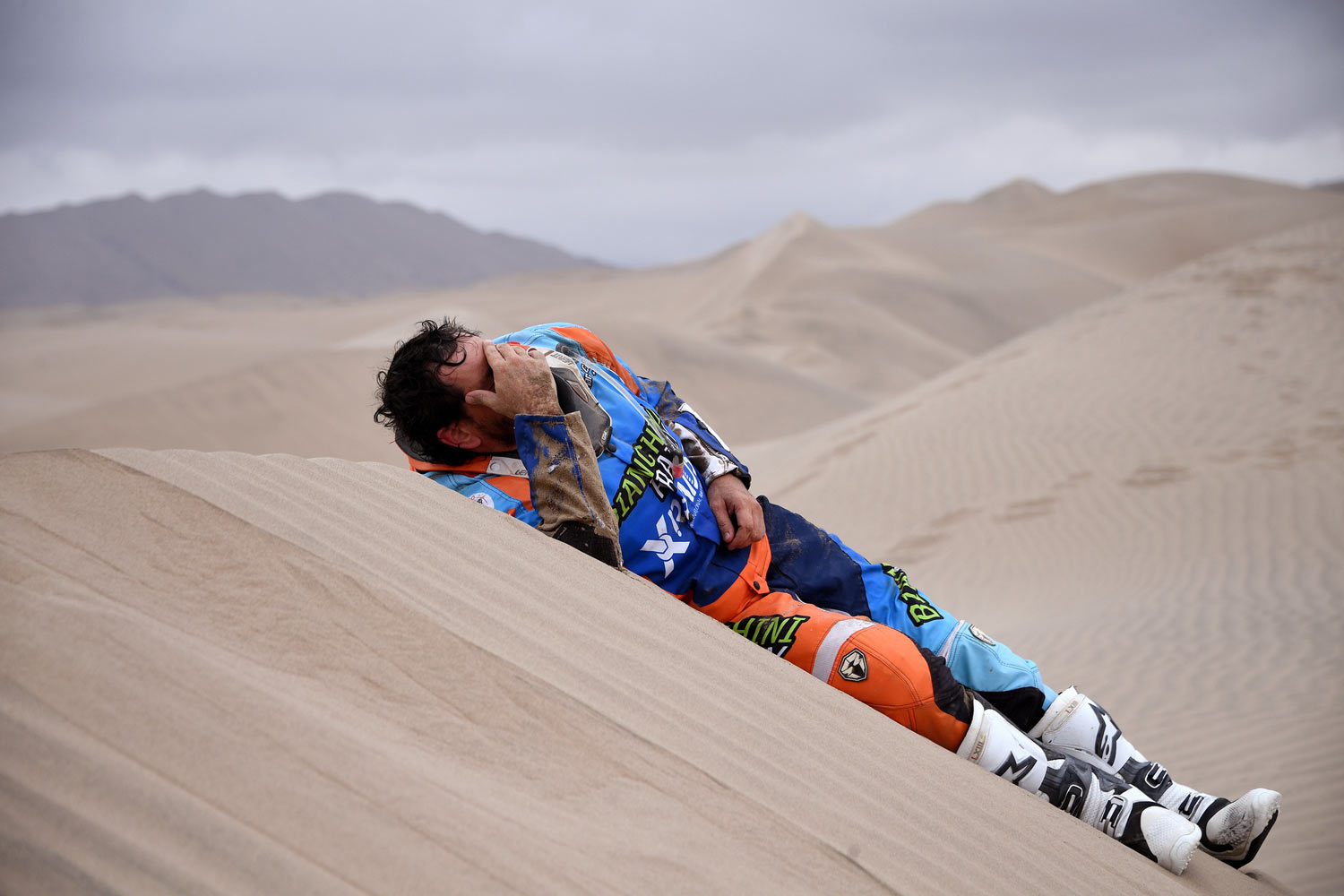 Marcos Colvero of Brazil lies on the dunes after he crashed on his KTM motorbike during the third stage of the Dakar Rally between San Juan de Marcona and Arequipa, Peru, Wednesday, Jan. 9, 2019. (Franck Fife/Pool Photo via AP)