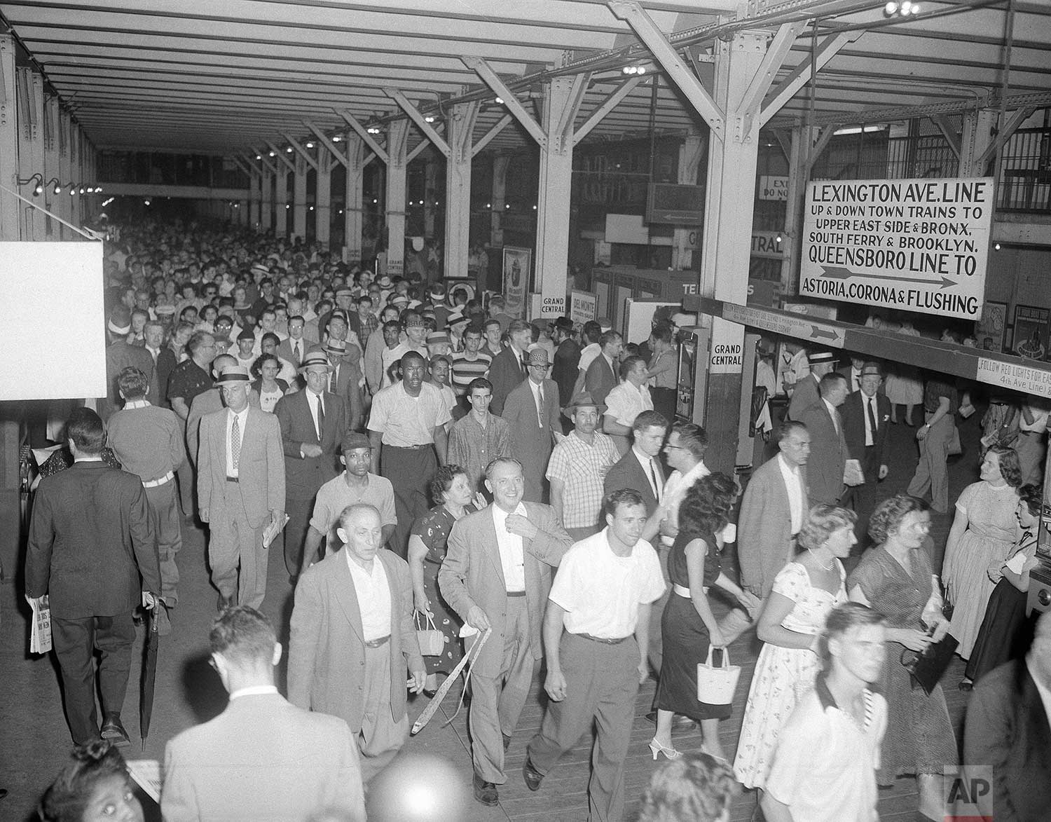  Crowds of homebound New Yorkers move slowly toward the Grand Central station of the IRT's Lexington Avenue line after leaving the crosstown shuttle during the peak of the rush hour, July 16, 1956. Flooding from water poured on the Wanamaker departme