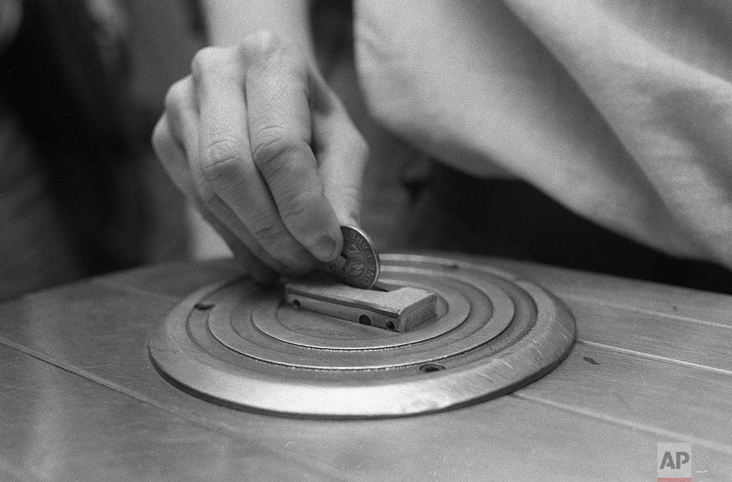  A New York subway rider inserts a token into a turnstile at the Rockefeller Center station, June 1980. (AP Photo) 