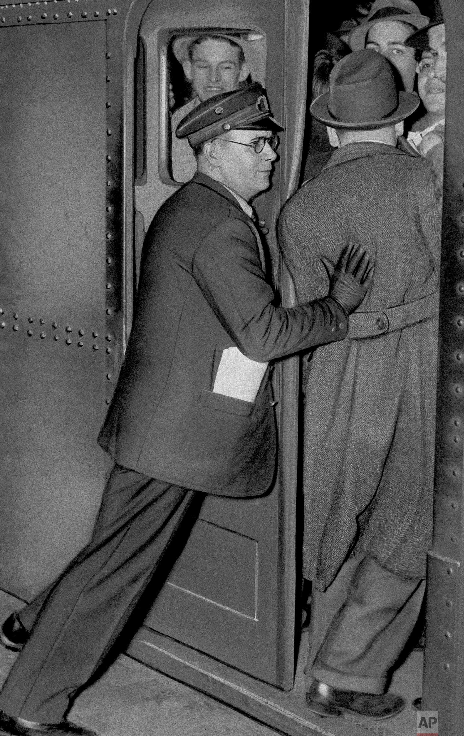  New York City subway worker squeezes one more onto a train car, May 5, 1943. (AP Photo) 