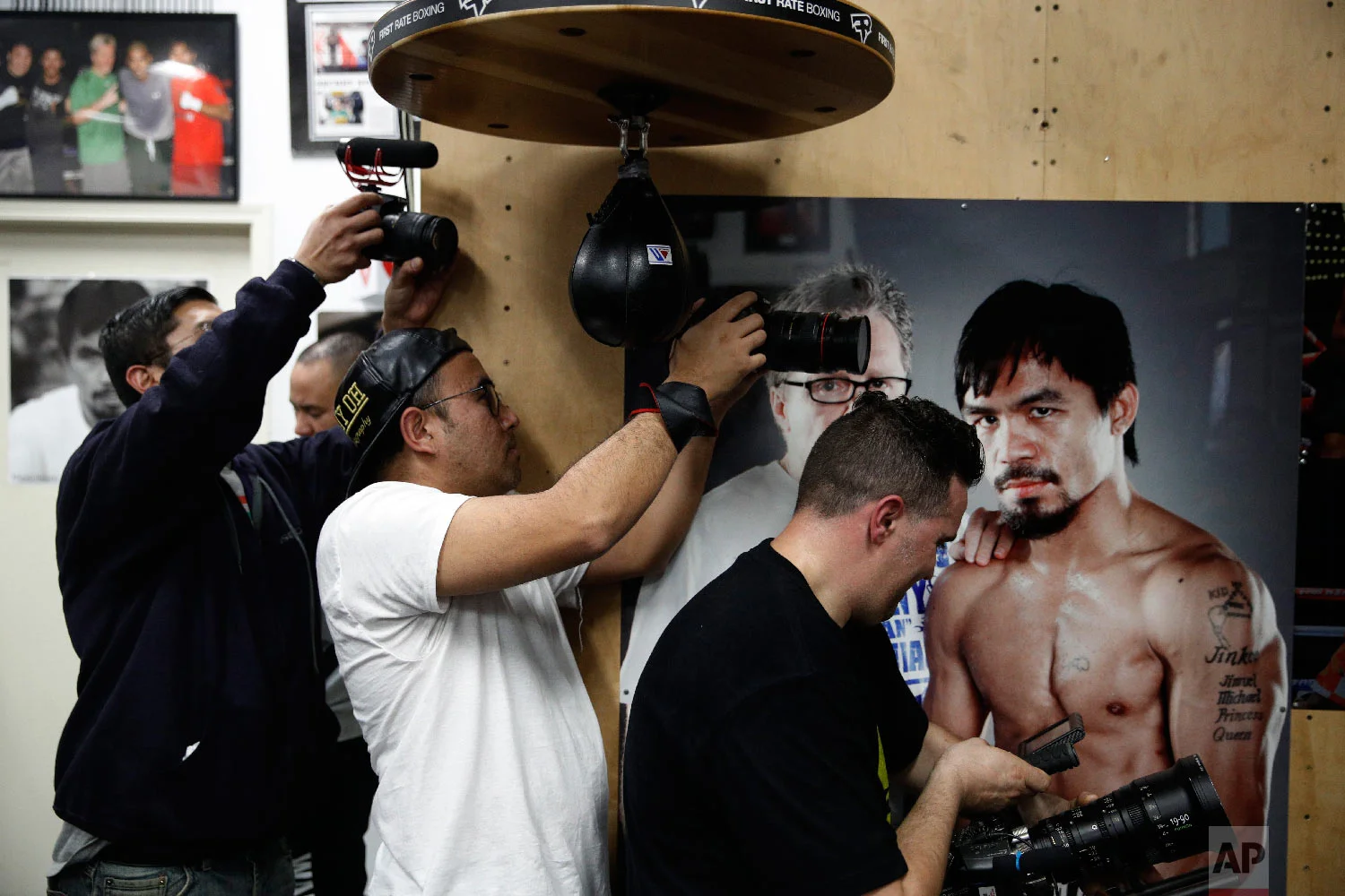Film production crew members record as boxer Manny Pacquiao, not pictured, hits a speed bag at the Wild Card Boxing Club on Jan. 14, 2019, in Los Angeles. (AP Photo/Jae C. Hong)