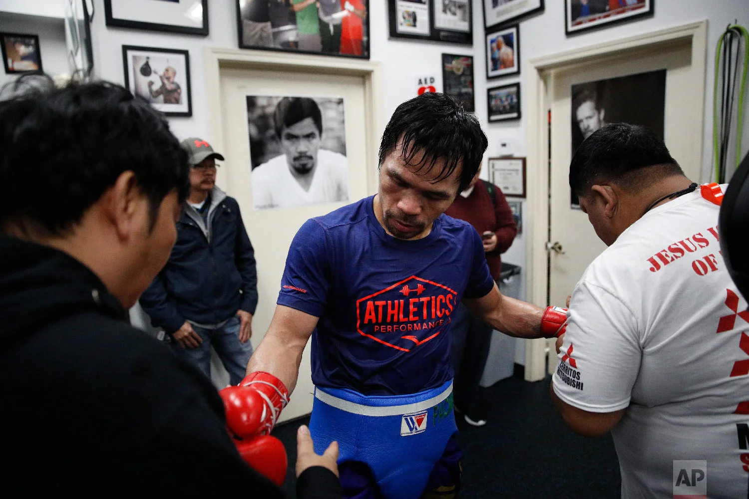 Soaked in sweat, boxer Manny Pacquiao gets his gloves removed after a workout at the Wild Card Boxing Club Monday, Jan. 14, 2019, in Los Angeles. (AP Photo/Jae C. Hong)