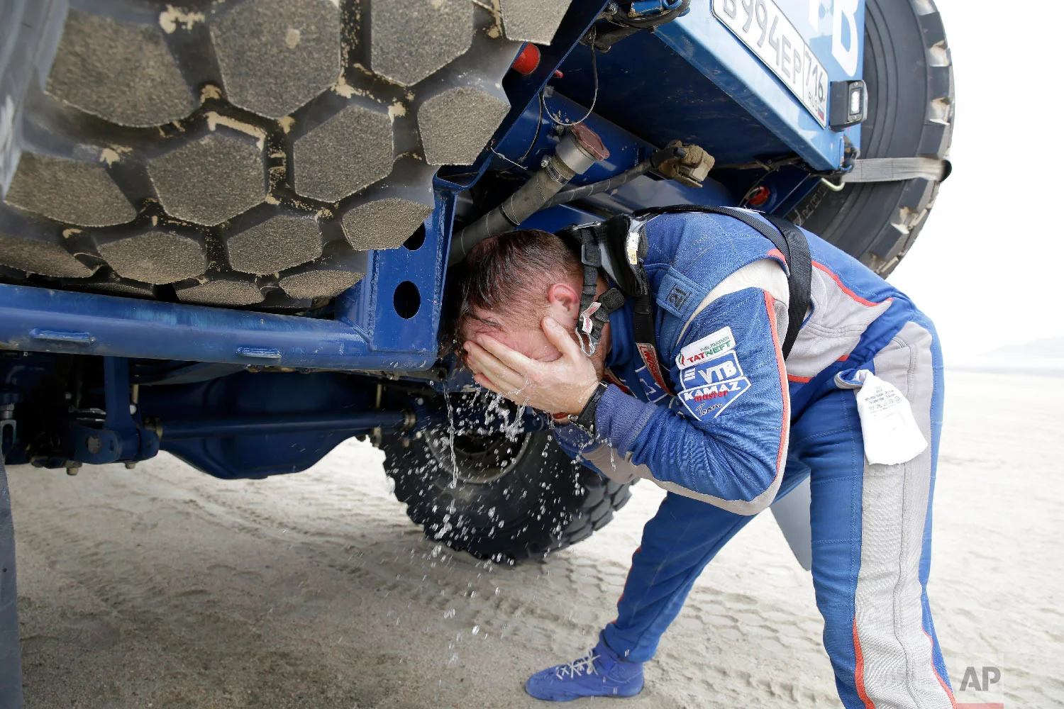 Kamaz truck driver Eduard Nikolaev, of Russia, refreshes at a stop during the stage eight of the Dakar Rally between San Juan de Marcona and Pisco, Peru, Jan. 15, 2019. (AP Photo/Ricardo Mazalan)