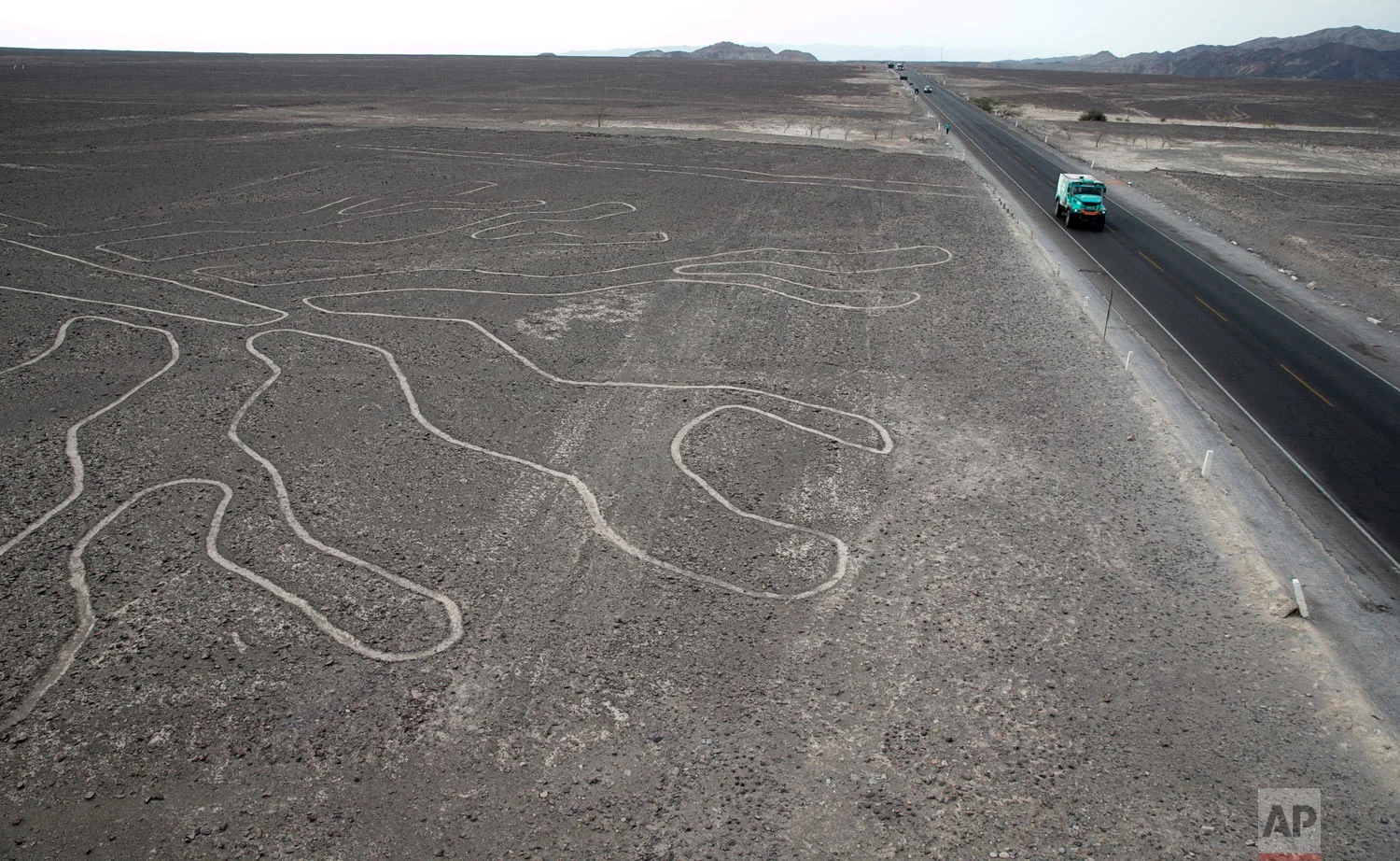 Driver Gerard De Rooy, of Netherlands, and co-drivers Darek Rodewald, of Poland, and Moises Torrallardona, of Spain, drive their Iveco truck on the Pan American highway along the Nazca Lines geoglyphs in Nazca, Peru, after finishing second in the second stage of the Dakar Rally between Pisco and San Juan de Marcona, Jan. 8, 2019. (AP Photo/Ricardo Mazalan)