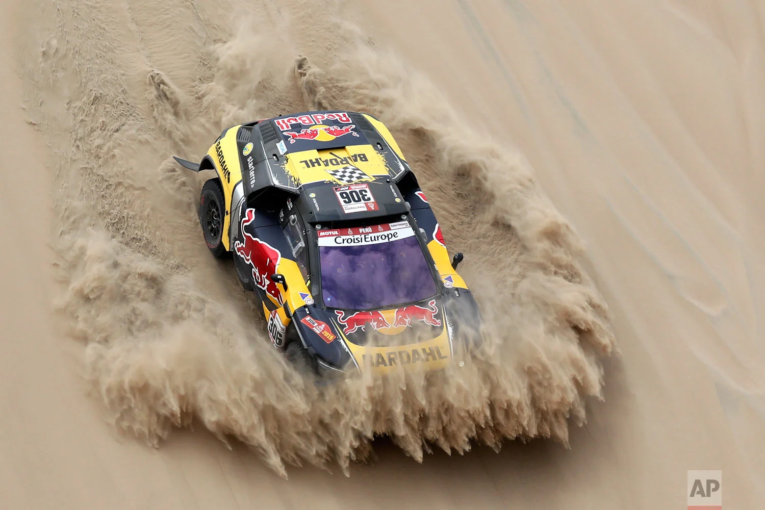 Driver Sebastien Loeb, of France, and co-driver Daniel Elena, of Monaco, race their Peugeot during the first stage of the Dakar Rally between Lima and Pisco, Peru, Jan. 7, 2019. (AP Photo/Ricardo Mazalan)