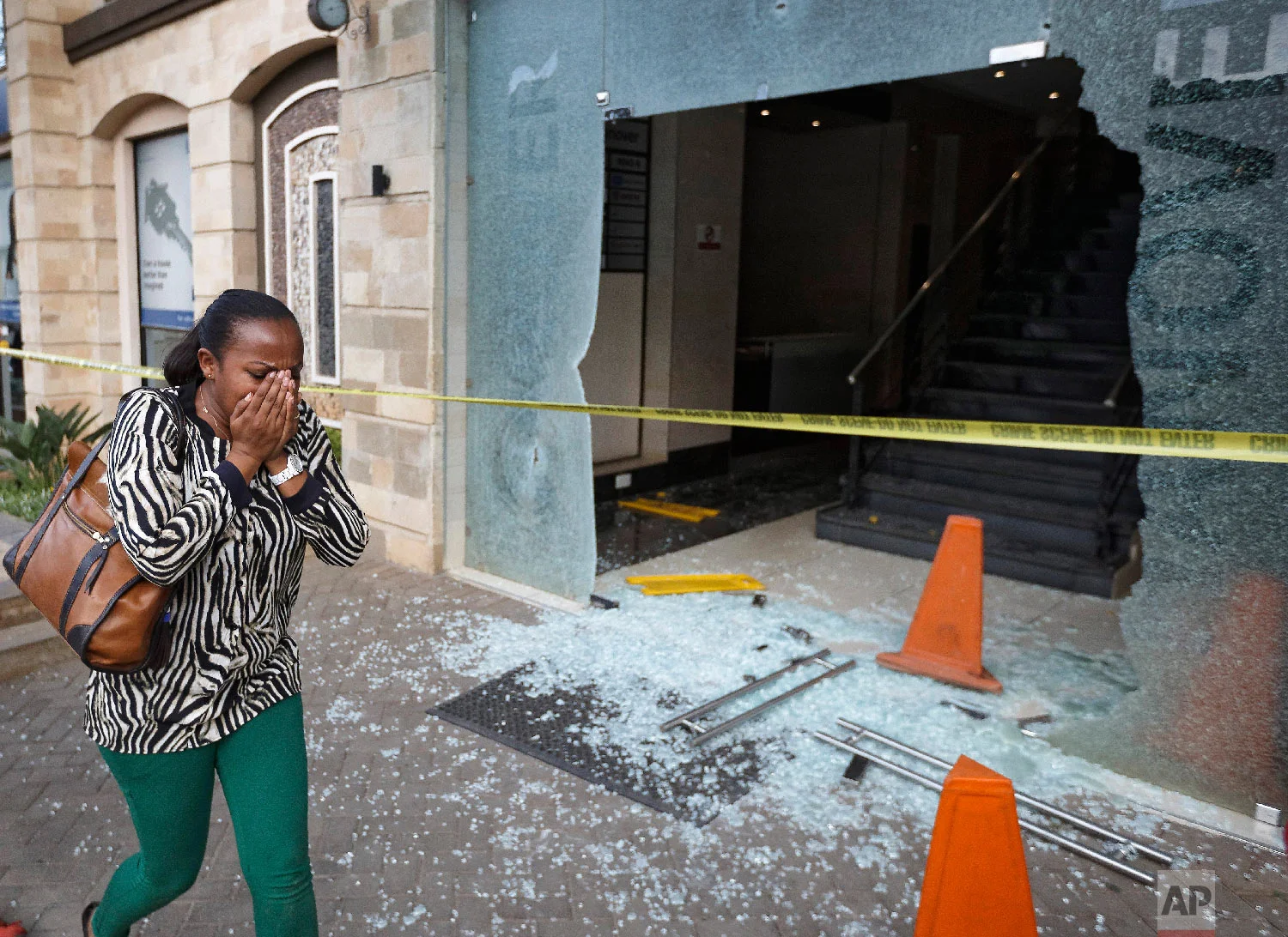 A woman reacts as she flees the scene at a hotel complex in Nairobi, Kenya, Jan. 15, 2019. (AP Photo/Ben Curtis)