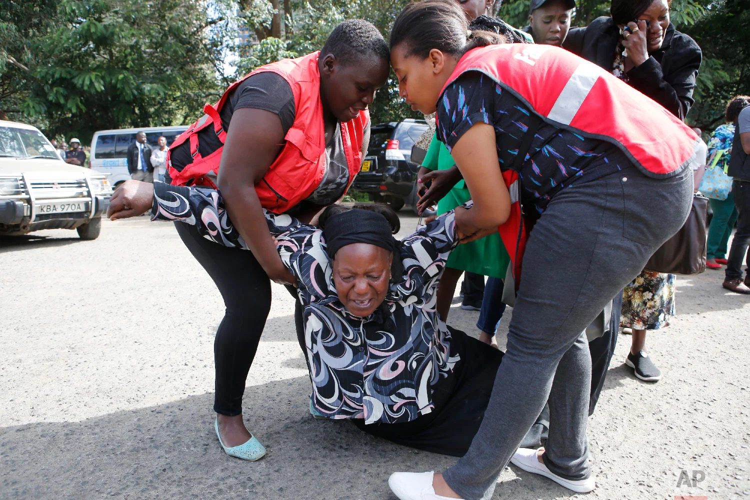 Kenya Red Cross personnel helps a woman reacting after learning of a family member killed during a recent terrorist attack, Jan. 16 2019, at the Chiromo Mortuary, Nairobi, Kenya. (AP Photo/Brian Inganga)