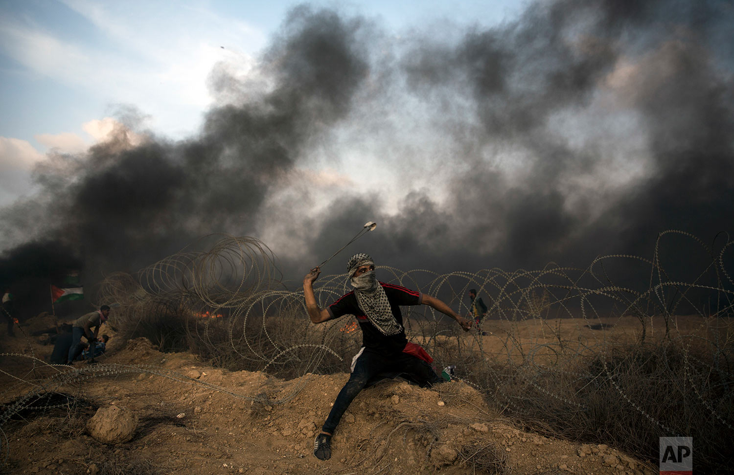  A Palestinian protester hurls stones towards Israeli troops at the Gaza Strip's border with Israel, Oct. 19, 2018. (AP Photo/Khalil Hamra) 