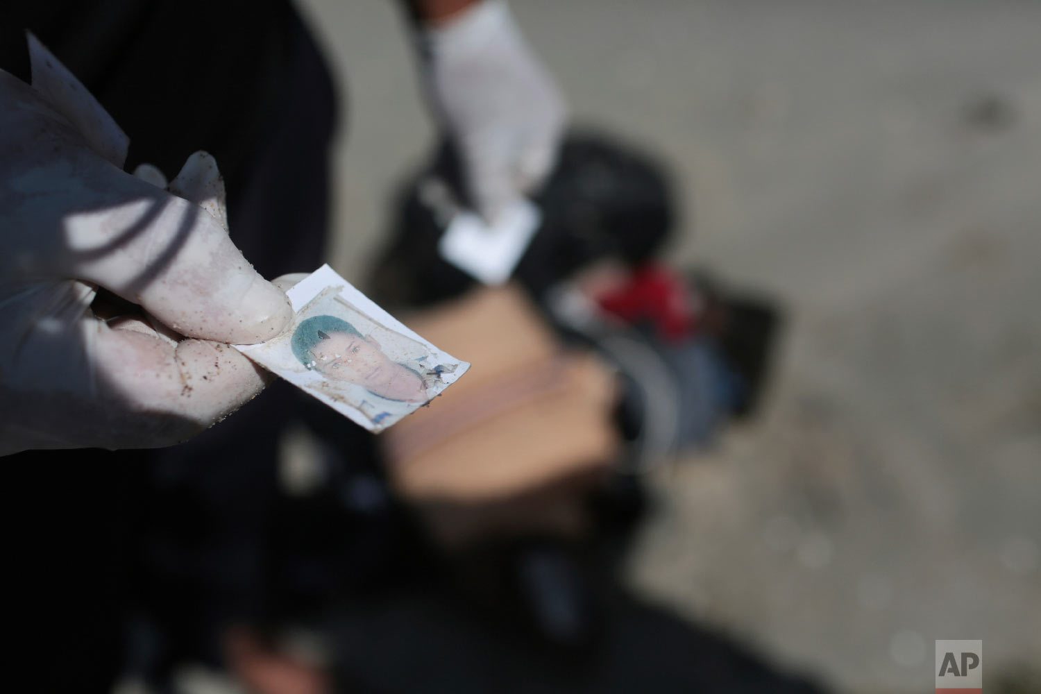 A Libyan Red Crescent worker holds a picture that was found in a bag of belongings that washed up on a beach near the Tunisian Libyan border, not far from Zuwarah, 102 km (63 mi) west of Tripoli, Libya, Saturday, Sept. 12, 2015.  (AP Photo/Mohamed B