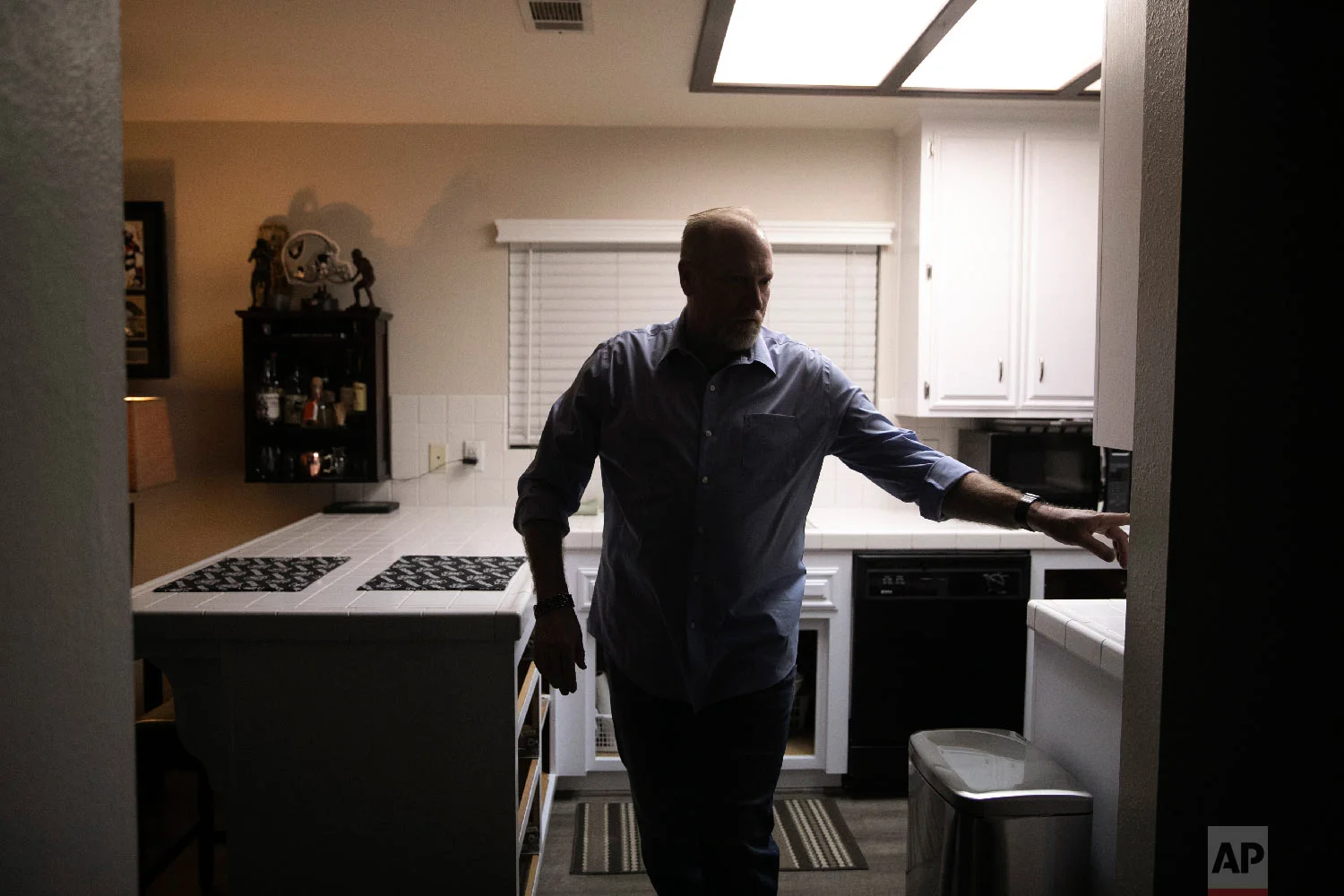 Chris George, a federal employee furloughed from his job as a forestry technician supervisor for the U.S. Department of Agriculture Forest Service, turns the kitchen lights off as he leaves home for a free meal offered to federal workers affected by the government shutdown Saturday, Jan. 19, 2019, in Hemet, Calif. (AP Photo/Jae C. Hong)