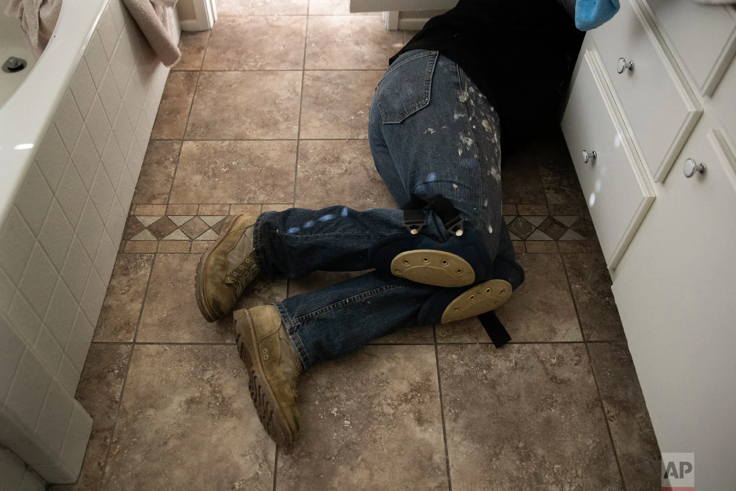 Chris George, a federal employee furloughed from his job as a forestry technician supervisor for the U.S. Department of Agriculture Forest Service, fixes a bathroom faucet, Saturday, Jan. 19, 2019, in Fontana, Calif. (AP Photo/Jae C. Hong)