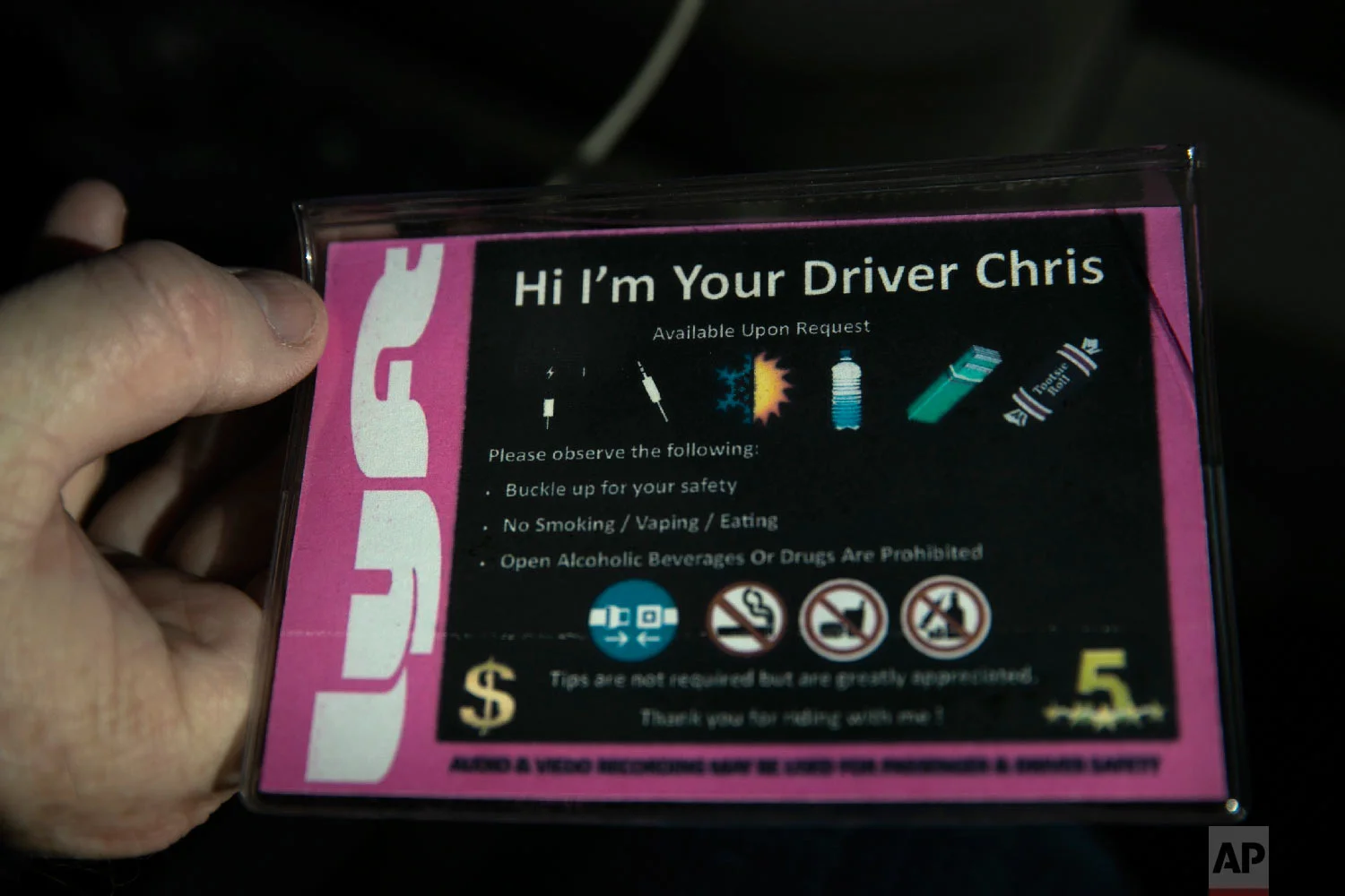 Chris George, a federal employee furloughed from his job as a forestry technician supervisor for the U.S. Department of Agriculture Forest Service, holds cards made for his Lyft passengers Monday, Jan. 21, 2019, in Redlands, Calif. (AP Photo/Jae C. Hong)