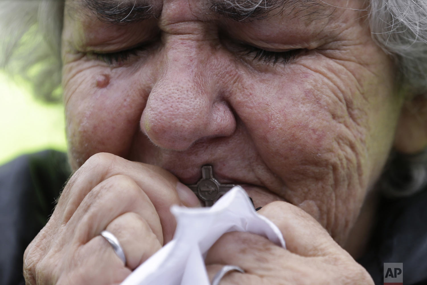 A woman kisses a cross during a rally to repudiate terrorism in Bolivar Square in Bogota, Colombia, Sunday, Jan. 20, 2019. The National Liberation Army claimed responsibility Monday for the deadly car bombing, stating the attack against a military installation was a legitimate response to the armed forces' bombing of a guerrilla camp during a recent unilateral ceasefire. (AP Photo/Fernando Vergara)