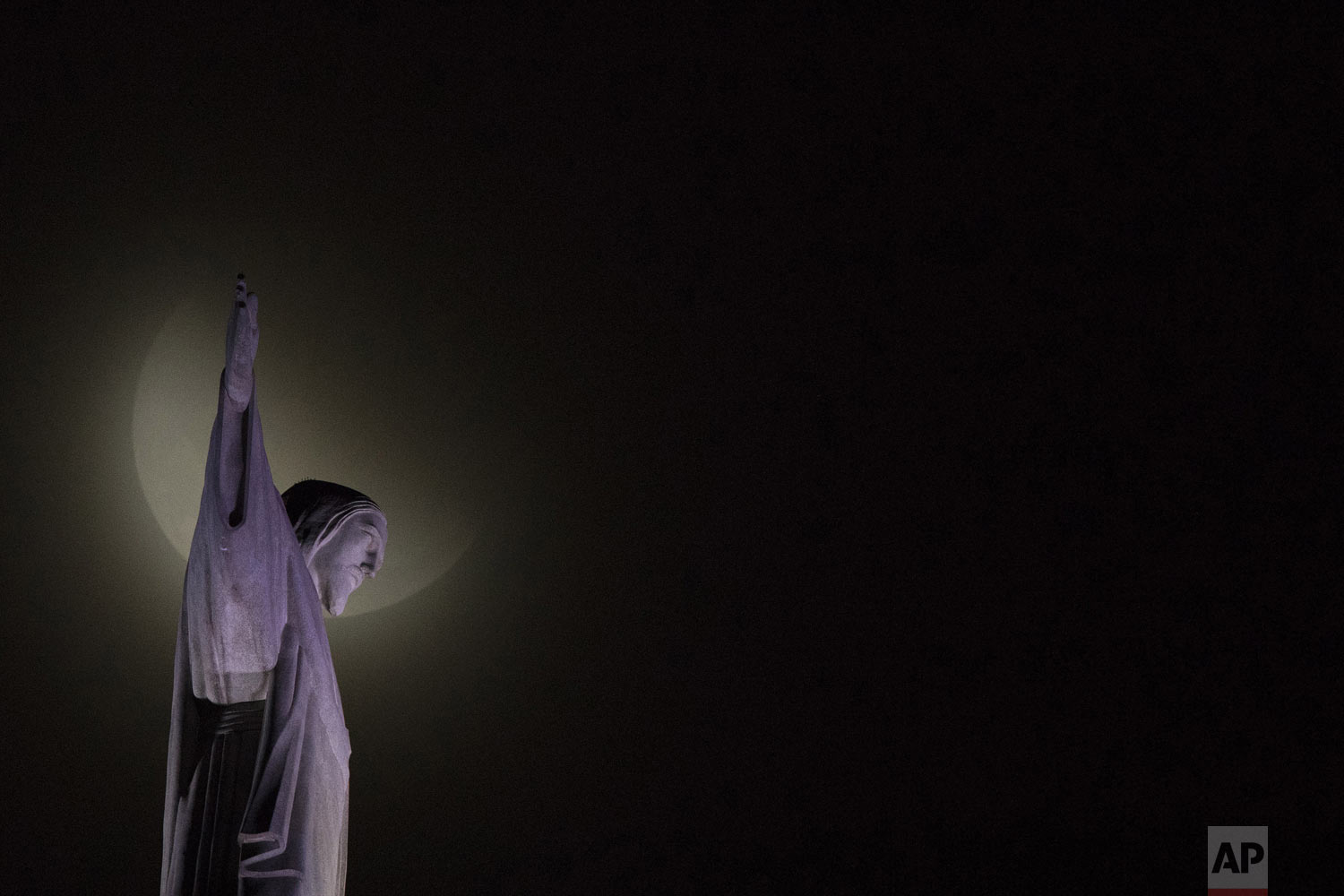 A blood moon rises above Christ the Redeemer statue during a lunar eclipse seen from Rio de Janeiro, Brazil, on Monday, Jan. 21, 2019. It's also the year's first supermoon, when a full moon appears a little bigger and brighter thanks to its closer distance to Earth. (AP Photo/Leo Correa)