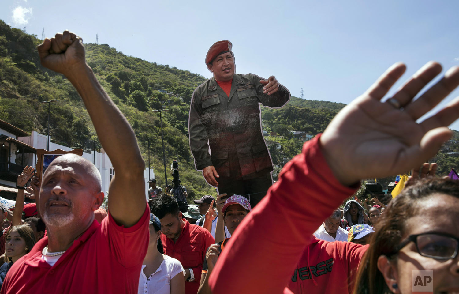  Government supporters hold a life-size image of Venezuela's late President Hugo Chavez during a rally in La Guaira, Venezuela, Friday, Jan. 25, 2019. Venezuelan President Nicolas Maduro, Chavez's protege, says he's willing to engage in talks with th