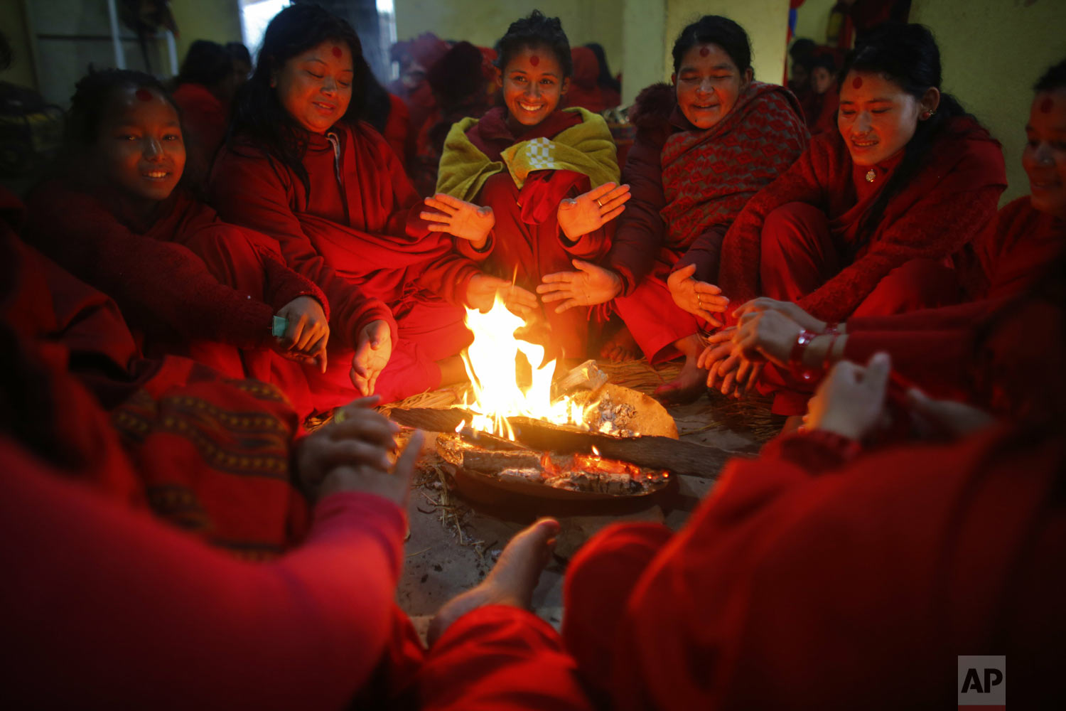 Devotees warm themselves up around a fire after taking a holy dip in the Sali River during Madhav Narayan festival in Sankhu, northeast of Kathmandu, Nepal, on Monday, Jan. 21, 2019. During the festival, worshippers recite holy scriptures dedicated to Hindu goddess Swasthani and Lord Shiva. Unmarried women pray for a good husband while those married pray for the longevity of their husbands by observing a month-long fast. (AP Photo/Niranjan Shrestha)