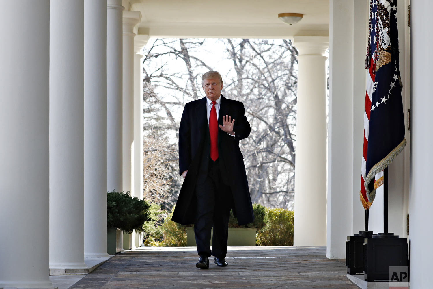  President Donald Trump waves as he walks through the Colonnade from the Oval Office of the White House on arrival to announce a deal to temporarily reopen the government, Friday, Jan. 25, 2019, from the Rose Garden of the White House in Washington. 