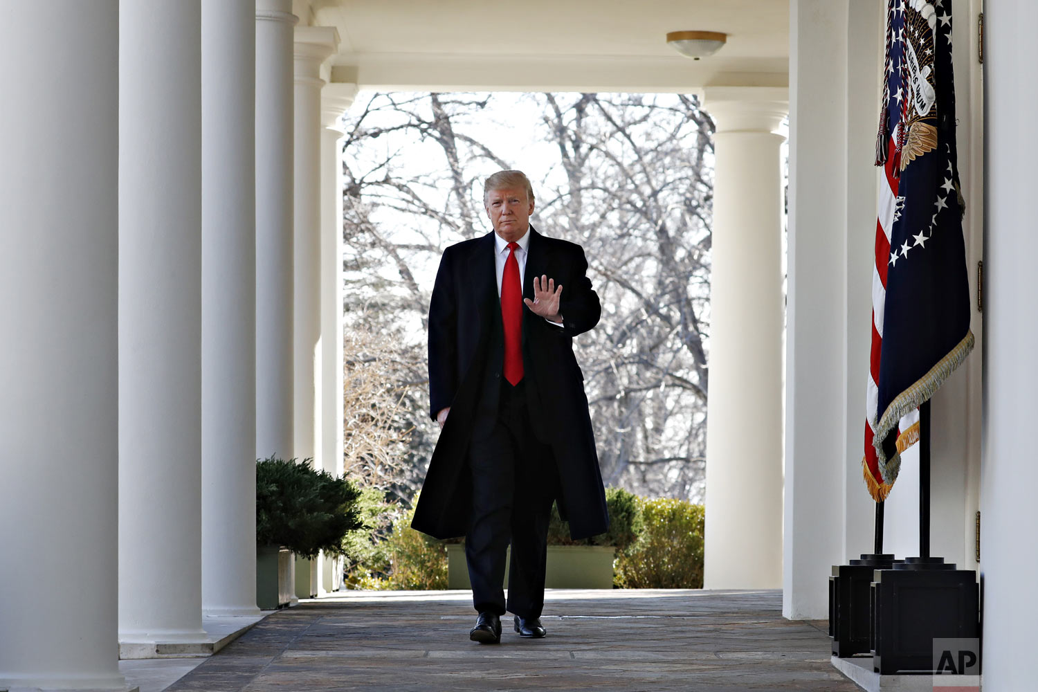 President Donald Trump waves as he walks through the Colonnade from the Oval Office of the White House on arrival to announce a deal to temporarily reopen the government, Friday, Jan. 25, 2019, from the Rose Garden of the White House in Washington. (AP Photo/Jacquelyn Martin)