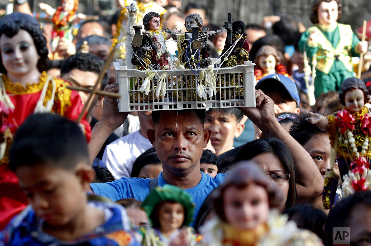 Roman Catholic devotees raise hundreds of images of the Child Jesus, known as Santo Niño, as they are blessed with holy water to celebrate its feast day in Manila, Philippines, on Sunday, Jan. 20, 2019. Many parishes around the country whose patron saint is the Child Jesus take part in the celebration which culminates in a Mass and procession. (AP Photo/Bullit Marquez, File)