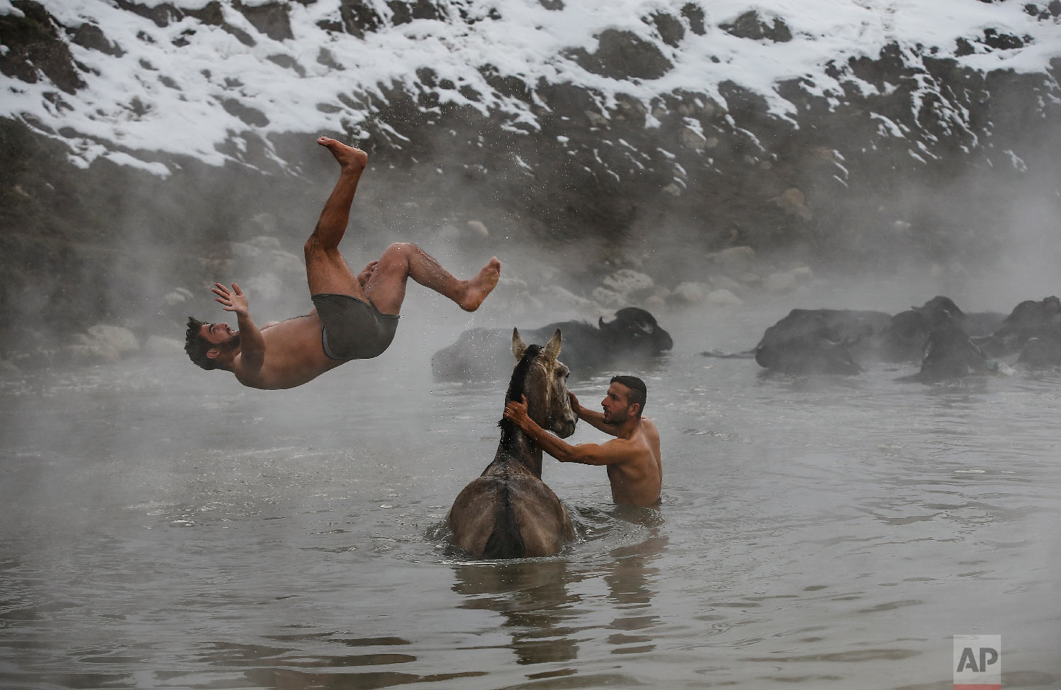  Muhammed Toren, 18, left, and Berkan Toren, 20, enjoy a hot spring along with their water buffaloes near the village of Budakli, in the mountainous Bitlis province of eastern Turkey, Thursday, Jan. 24, 2019. (AP Photo/Emrah Gurel) 